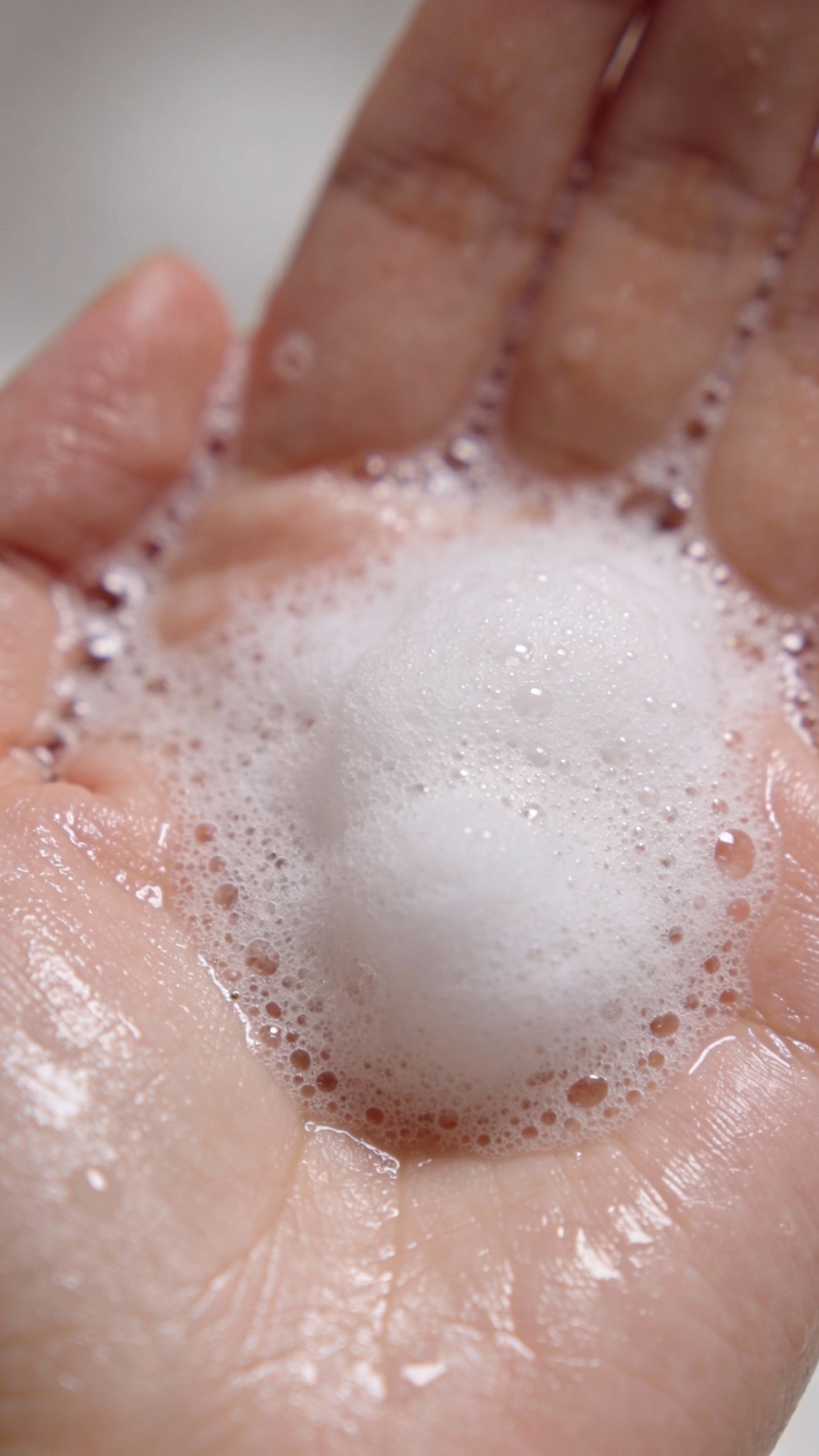foaming gentle cleanser on wet palm, macro skincare shot