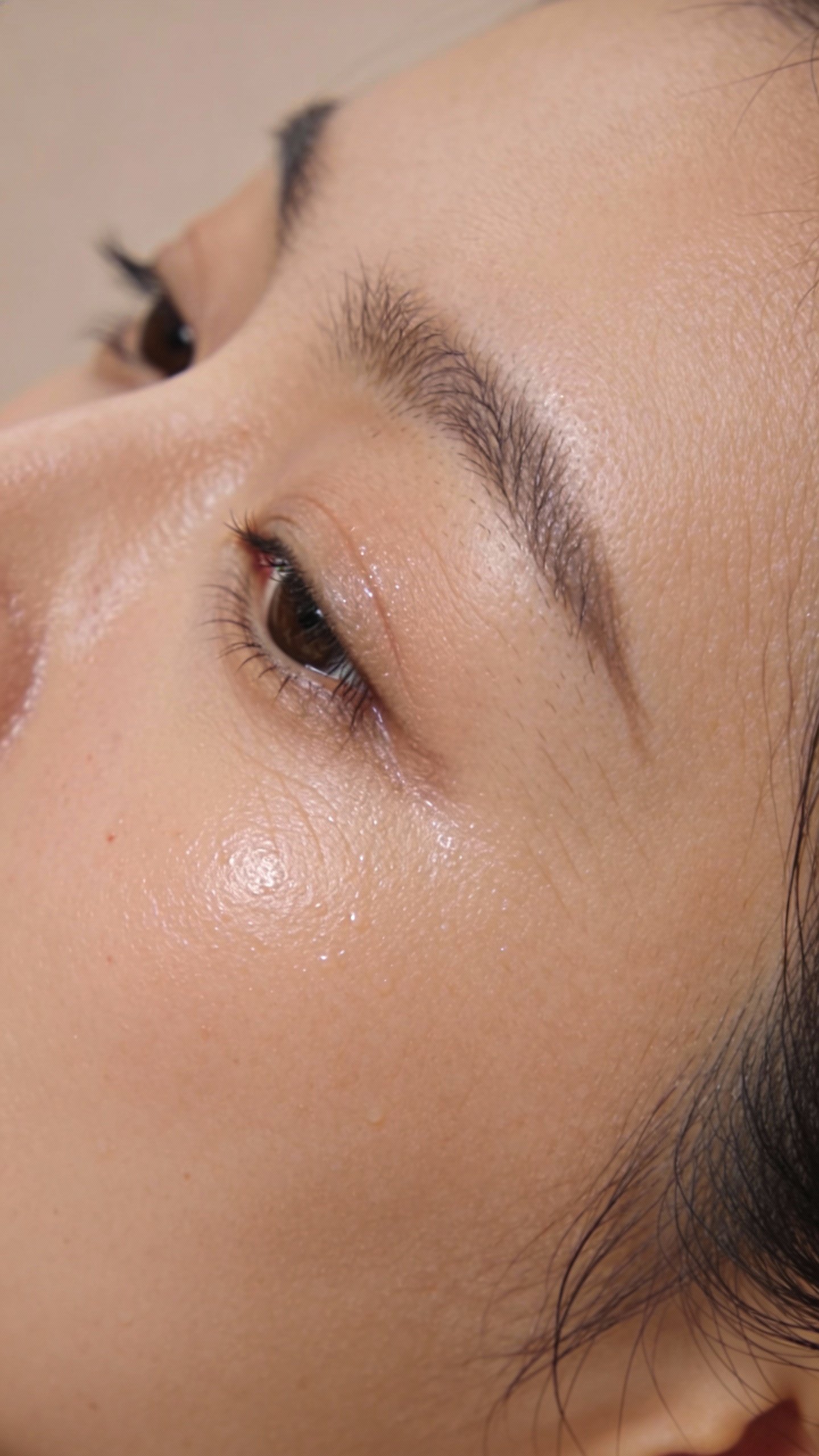 closeup of dewy cheek with visible fine lines soft light