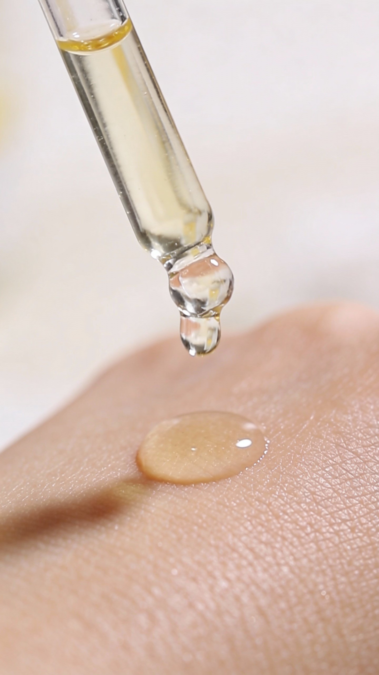 closeup of vitamin C serum dropper on pale skin