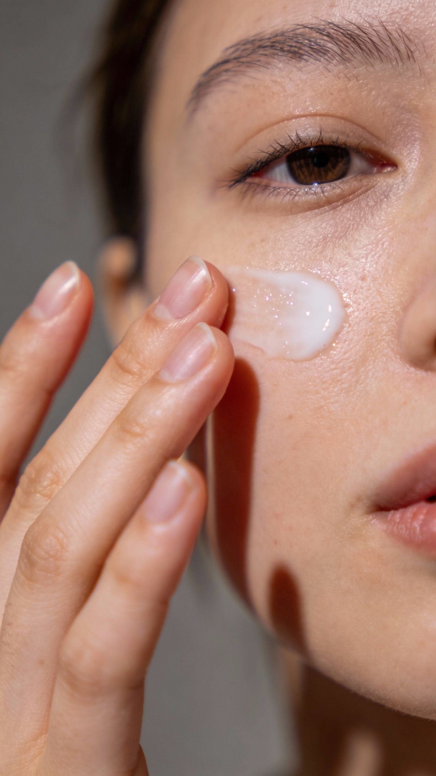 Closeup of hand smoothing SPF moisturizer onto cheek