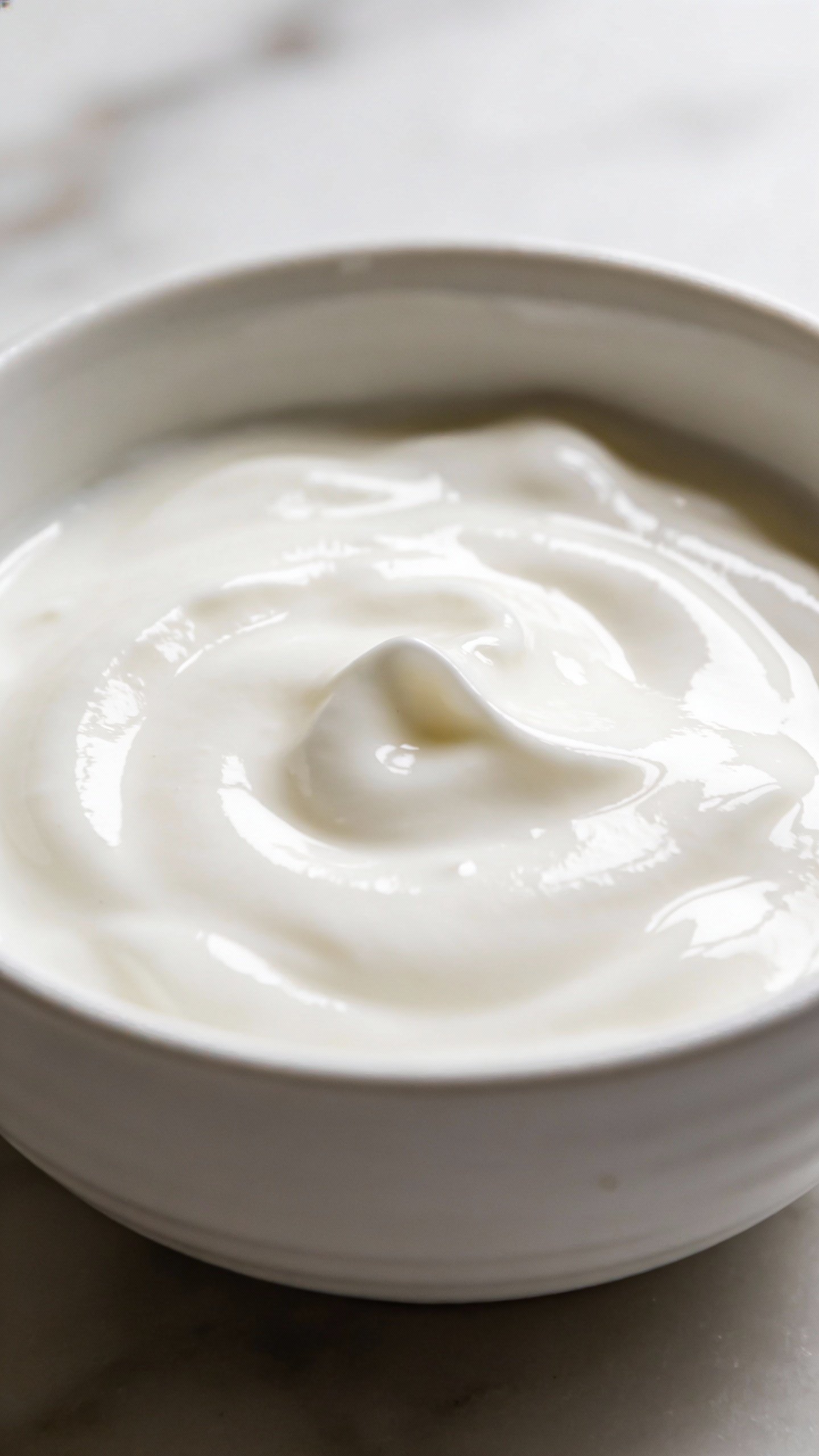 bowl of plain yogurt with a smooth glossy surface