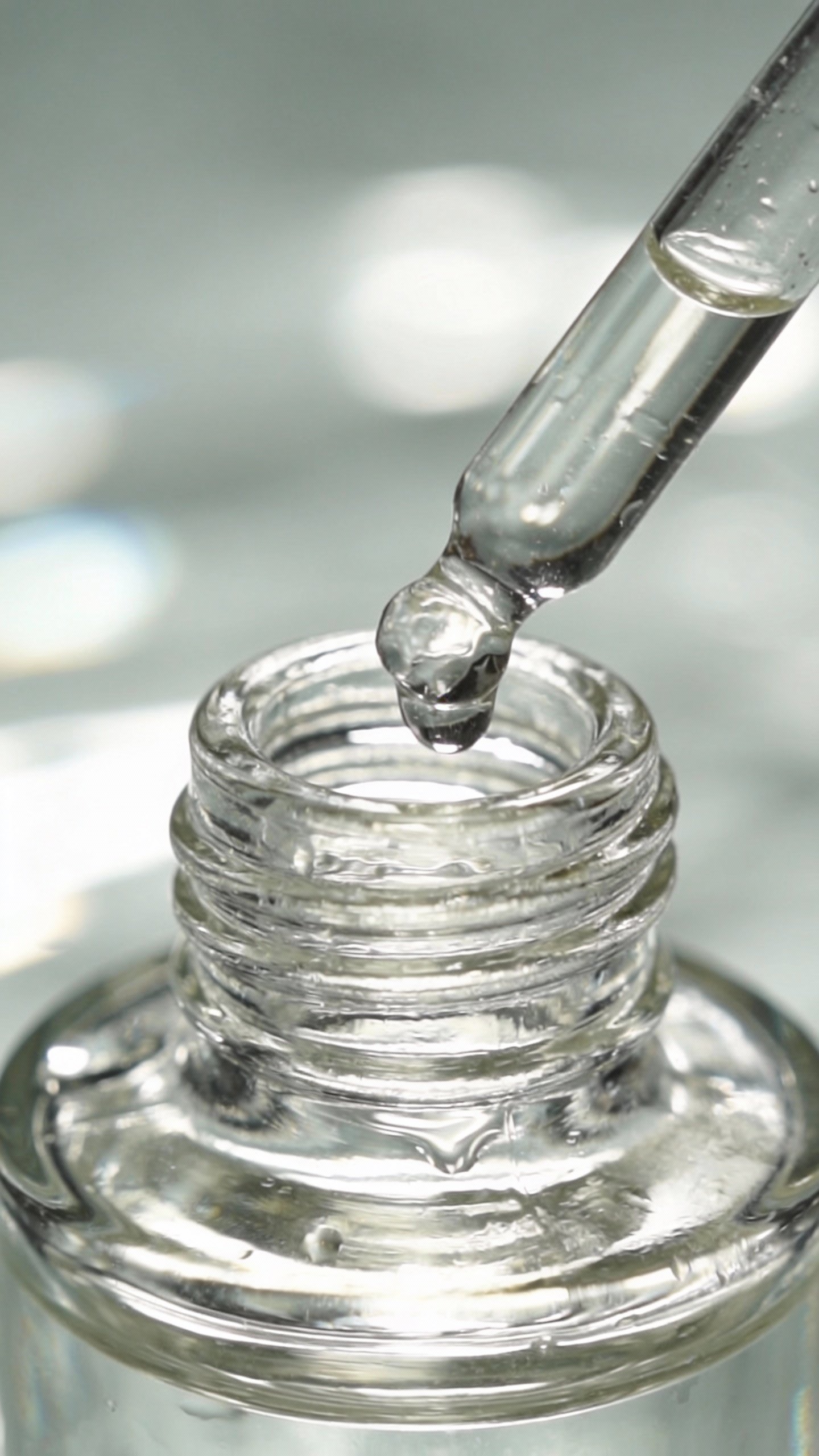 clear glass dropper bottle with watery essence, macro closeup