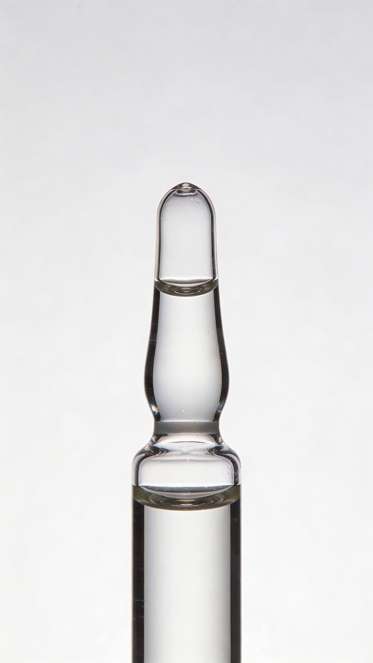 sterile glass dropper with clear serum, white background