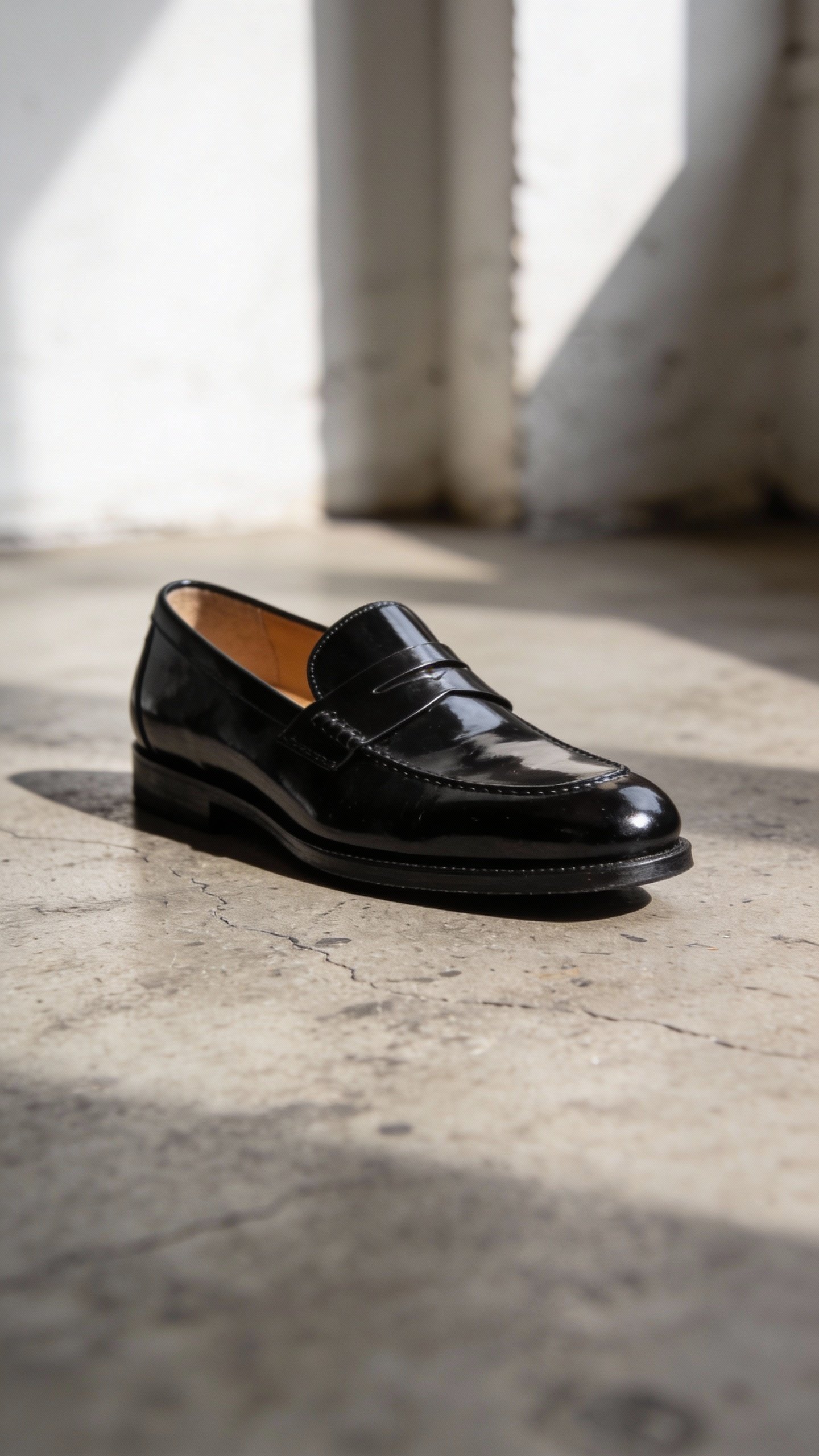 polished black loafer on concrete floor, soft natural light