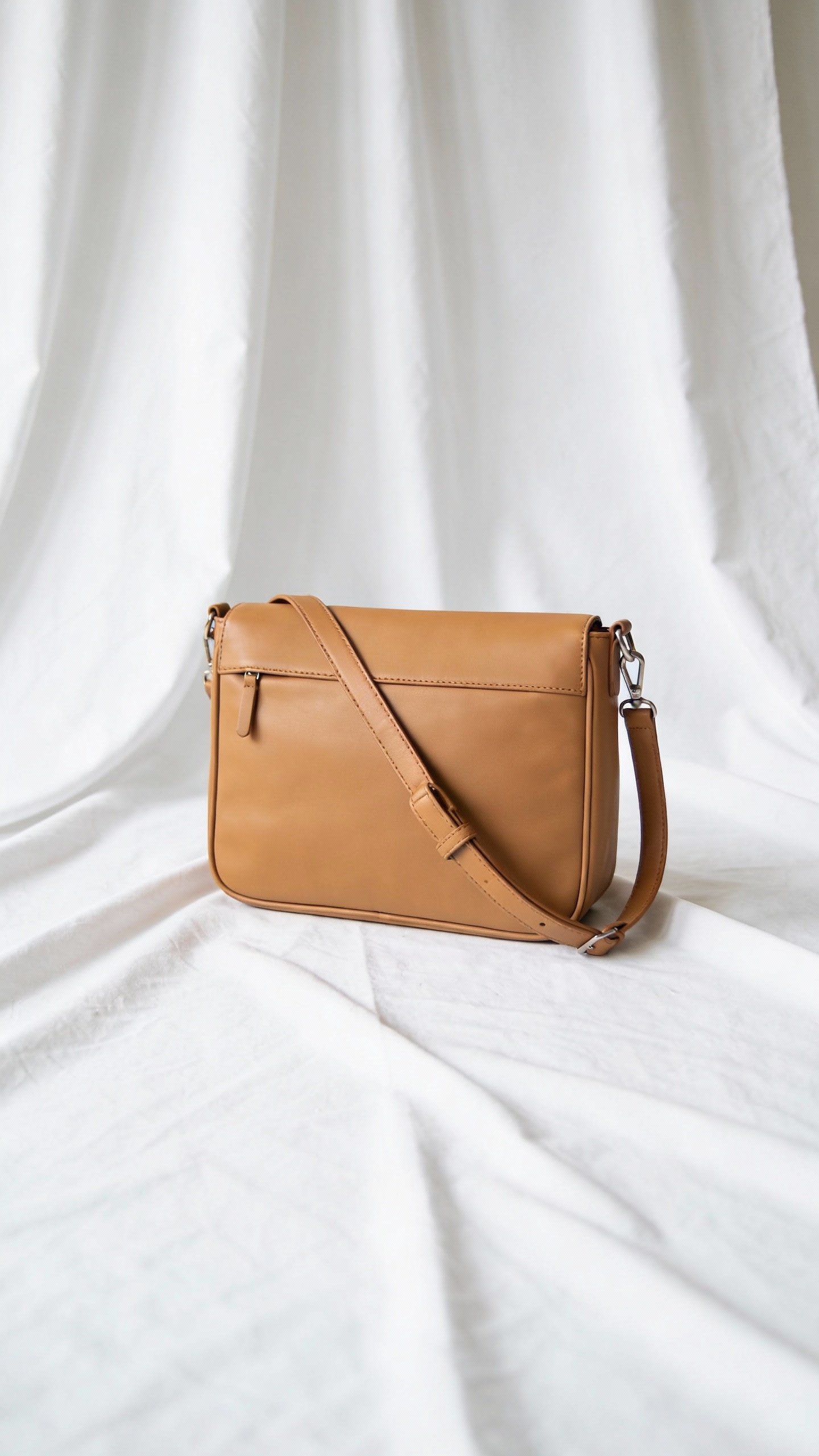 minimalist leather crossbody diaper bag, camel, on clean backdrop