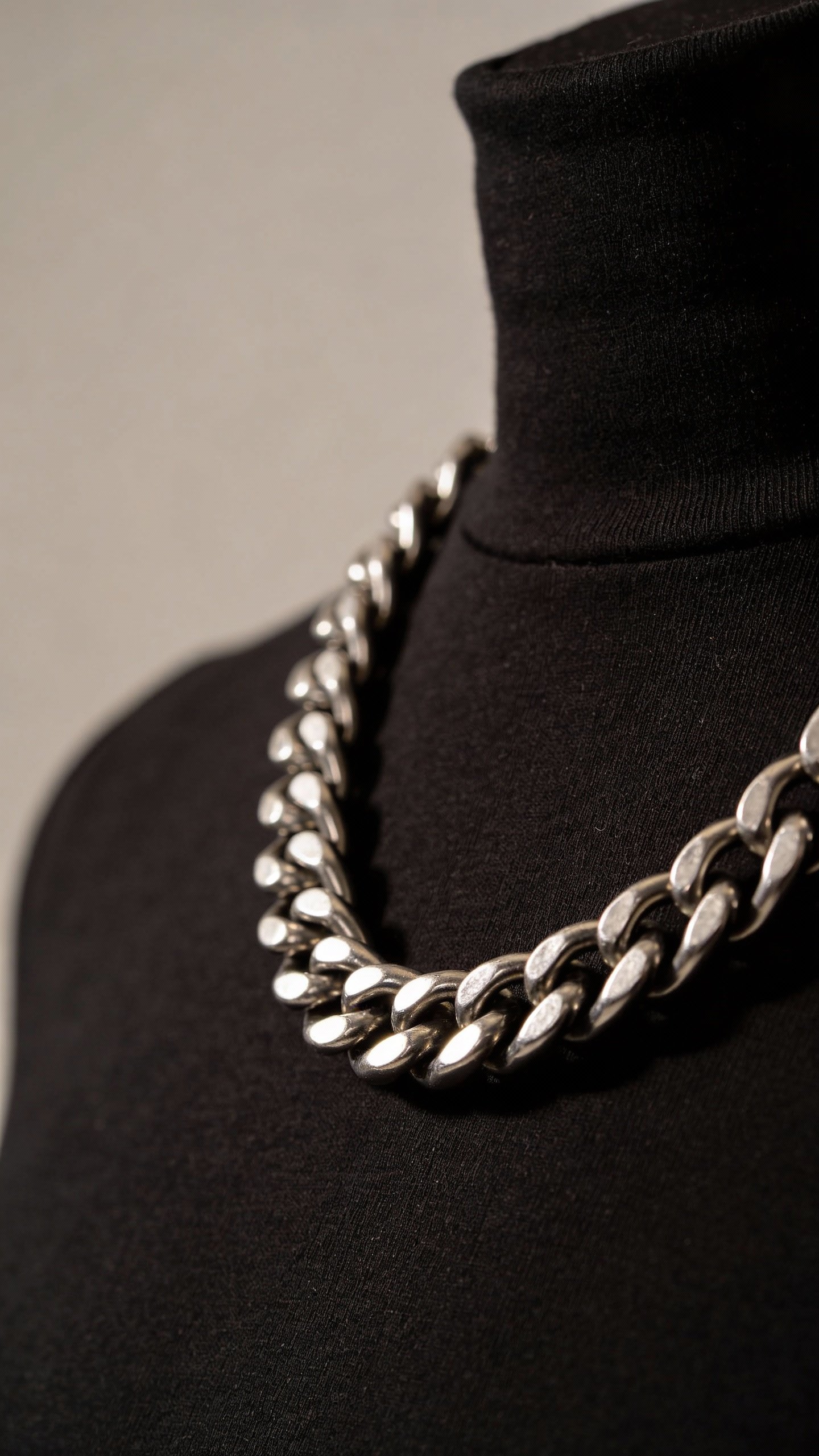 single chunky curb chain necklace on black turtleneck, studio lighting