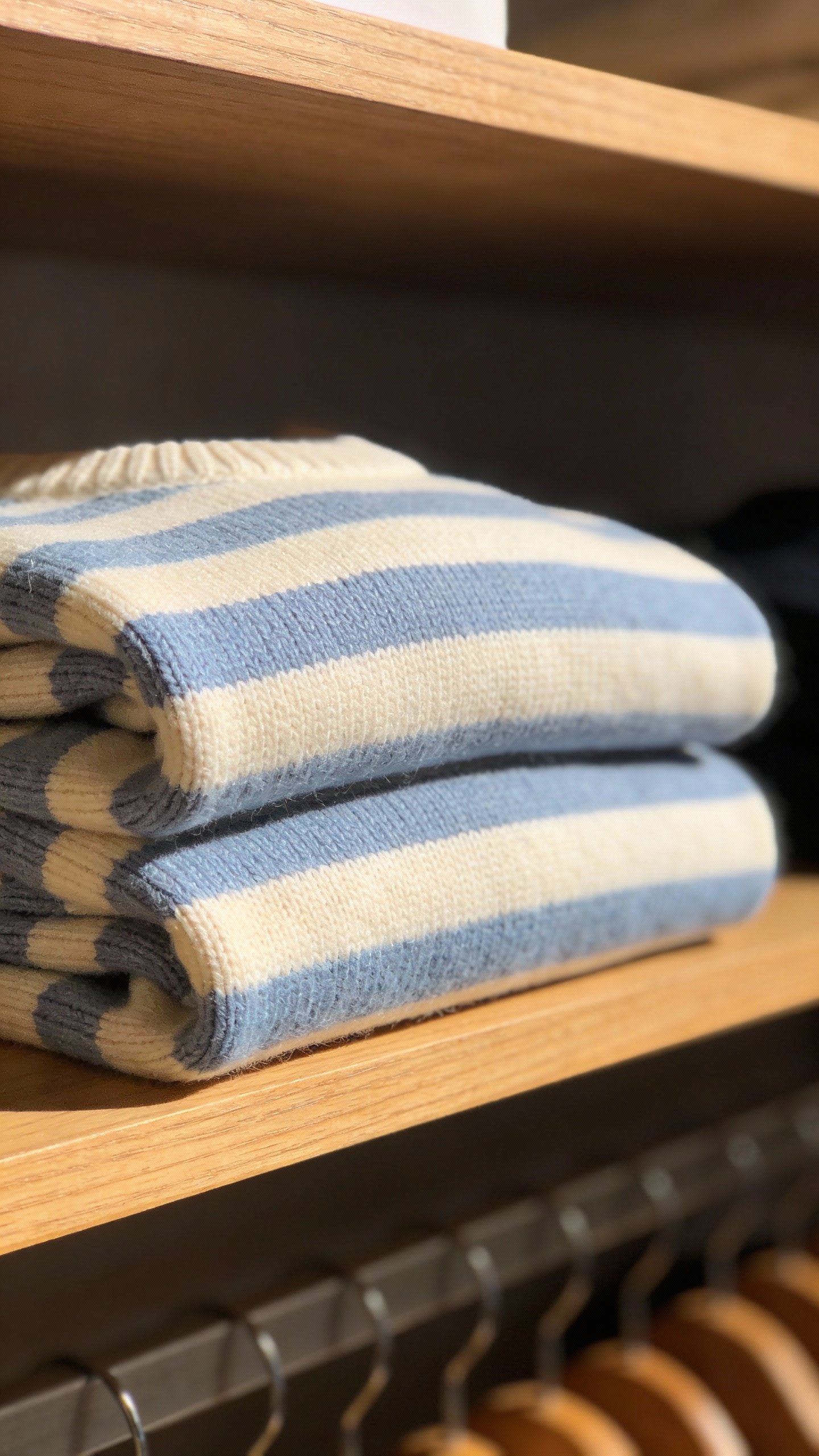 closeup of a single neatly folded striped sweater on shelf