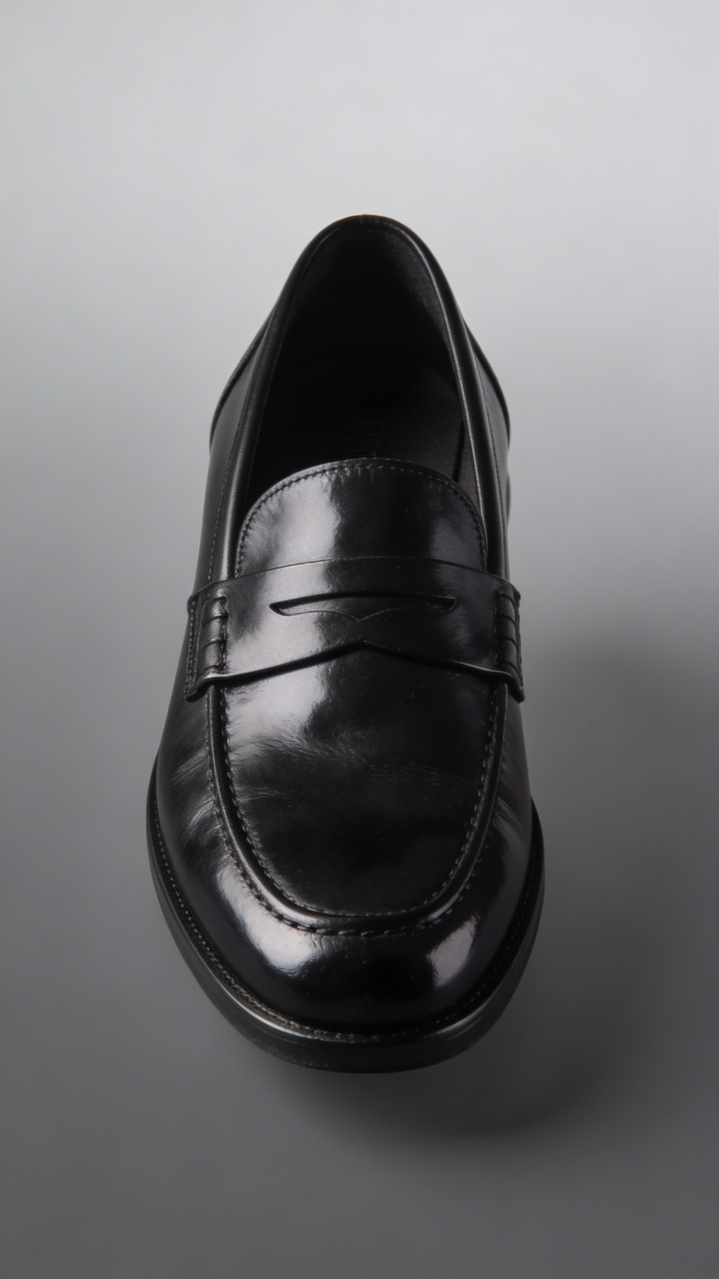 black leather loafer with subtle shine, isolated on gray gradient